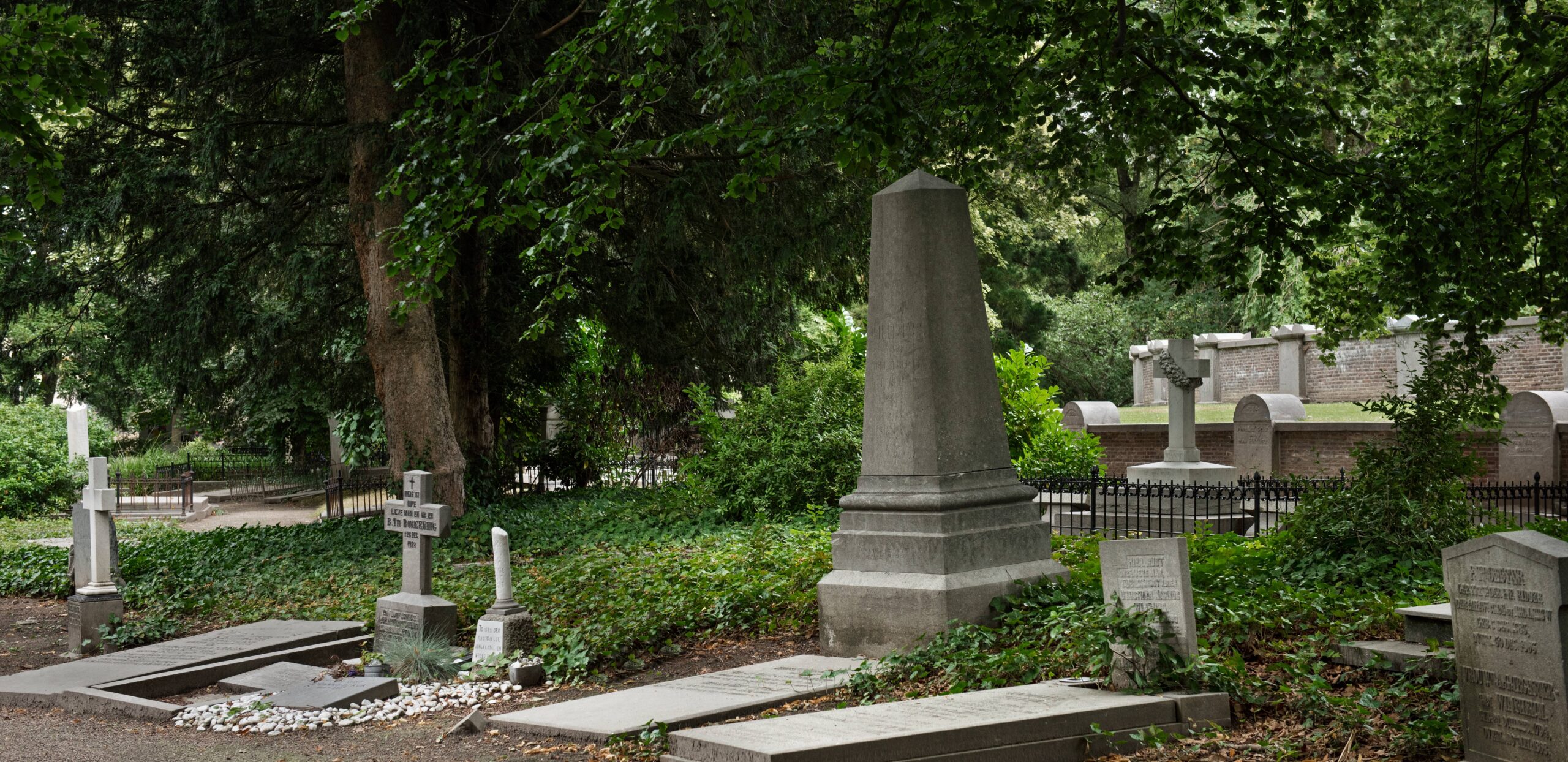 19th-century cemetery scene with old gravestones and mature trees