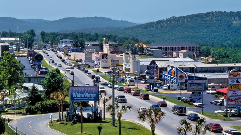 A view of Branson, Missouri’s main entertainment corridor with theaters, hotels, and the Ozark hills in the background.